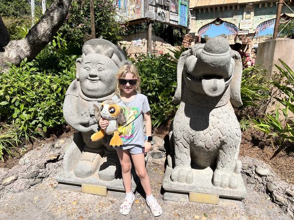 Mia in Asia in front of statues at Animal Kingdom in Walt Disney World