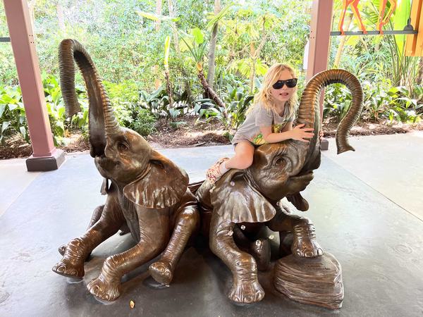 Mia posing with elephant statues at Rafiki's Planet Watch at Animal Kingdom