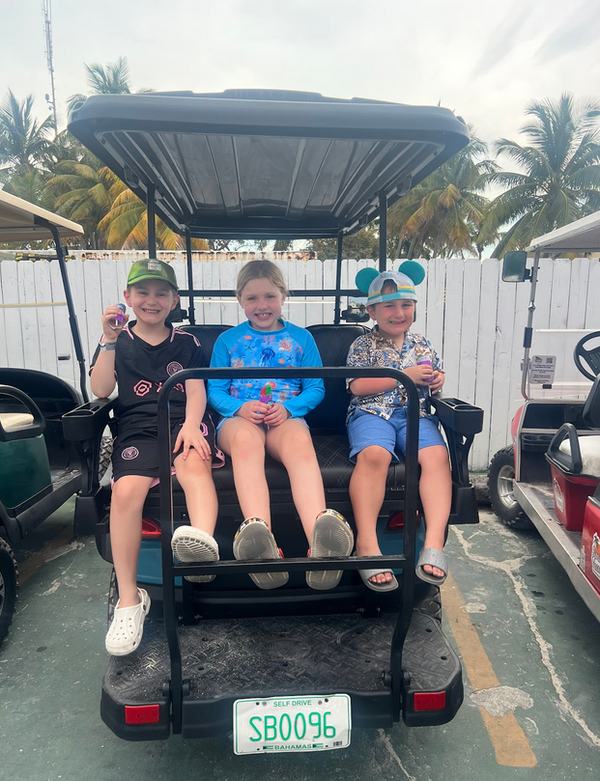 Bennett, Mia, and Tav in the golf cart