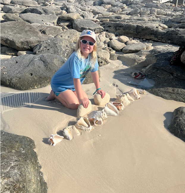 Mia collecting conch shells on the beach in Bimini